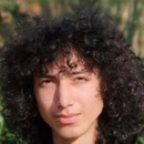 Person with curly hair in a natural outdoor setting